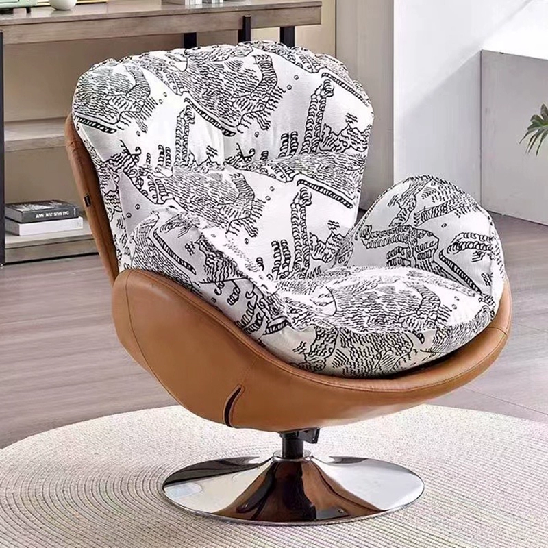 A Modern Swivel Accent Chair With a Brown Faux Leather Shell and a White And Black Patterned Fabric Cushion