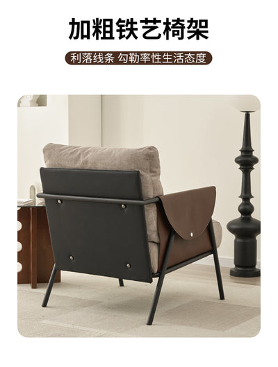 Lounge Chair With A Black Metal Frame, Light Grey Fabric Cushions, And Dark Brown Leather Armrests