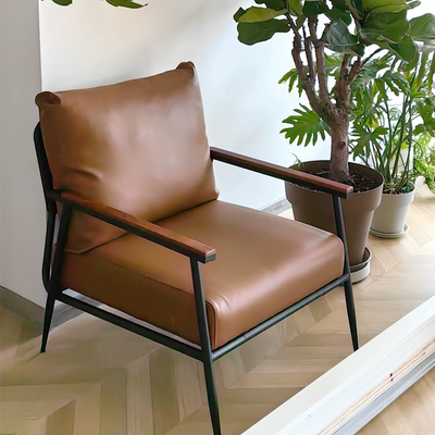An Industrial-style Armchair With A Black Metal Frame, Wooden Armrests, and Tan Faux Leather Upholstery