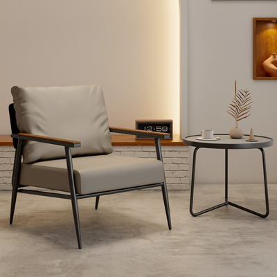 An Industrial-style Armchair With A Black Metal Frame, Wooden Armrests, and Tan Faux Leather Upholstery